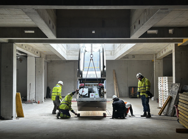 Monteure arbeiten an einer Fahrtreppe bei offenem Dach